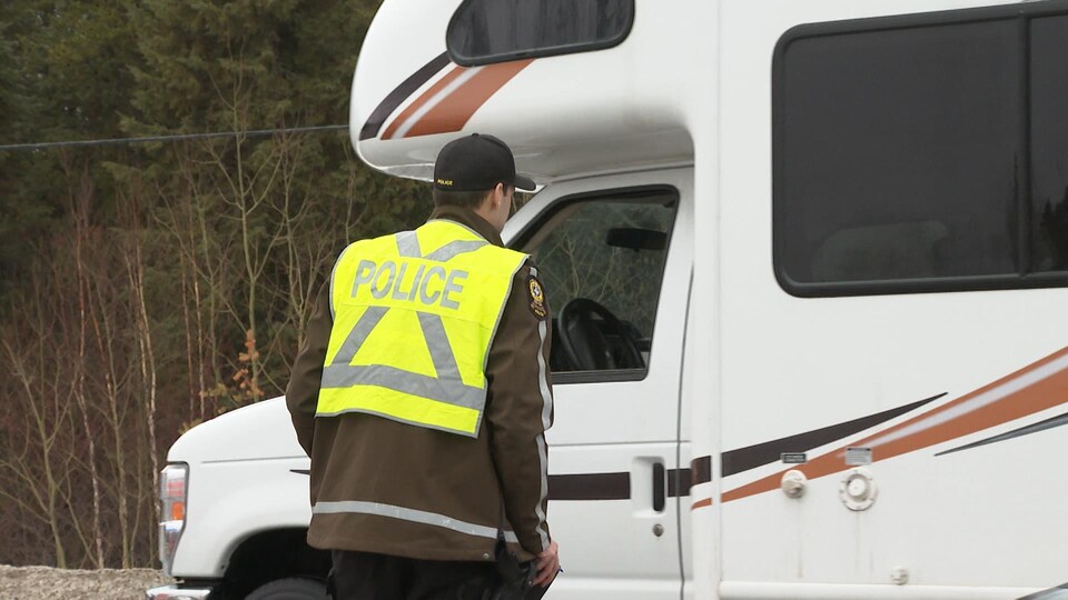 Un policier interroge le conducteur d'un camion-roulotte.