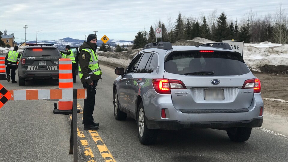 Des policiers de la Sûreté du Québec contrôlent la circulation.