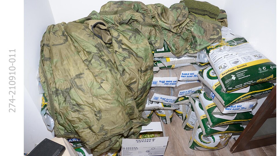 Des sacs empilés, recouverts d'une couverture de camouflage.
