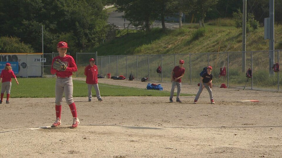 De jeunes joueurs de baseball sur un terrain.