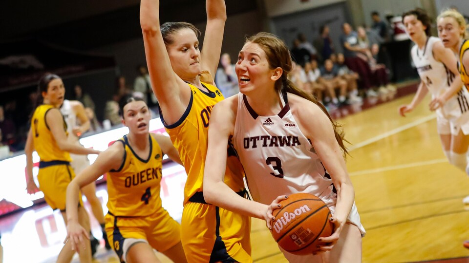 Une joueuse des Gee-Gees tente de marquer contre une joueuse des Gaels.
