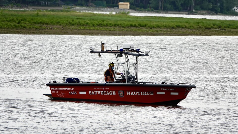 Un bateau de sauvetage patrouille la rivière des Prairies.