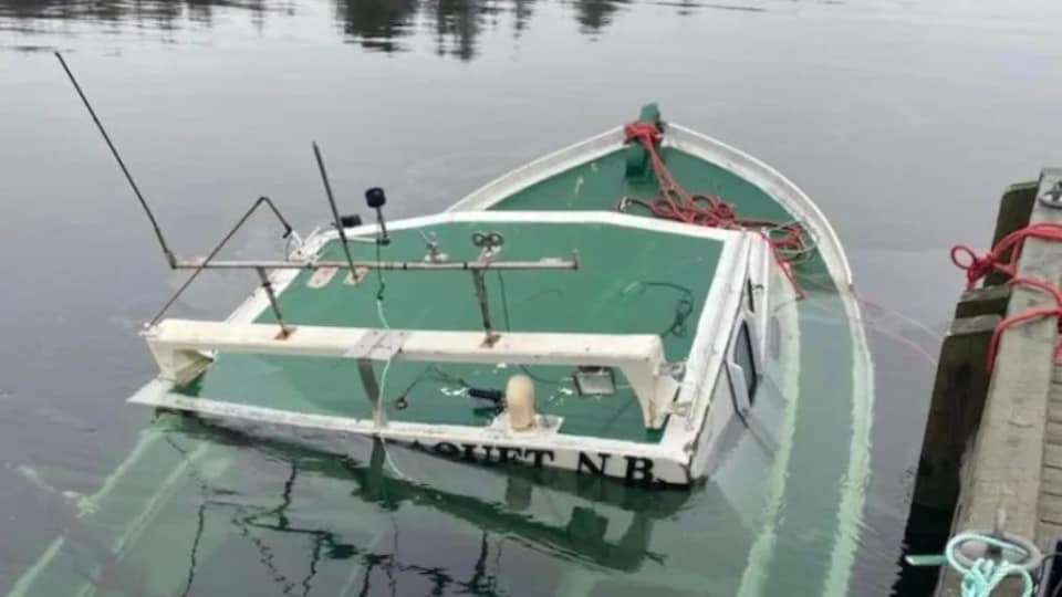 Un bateau coulé attaché au quai.