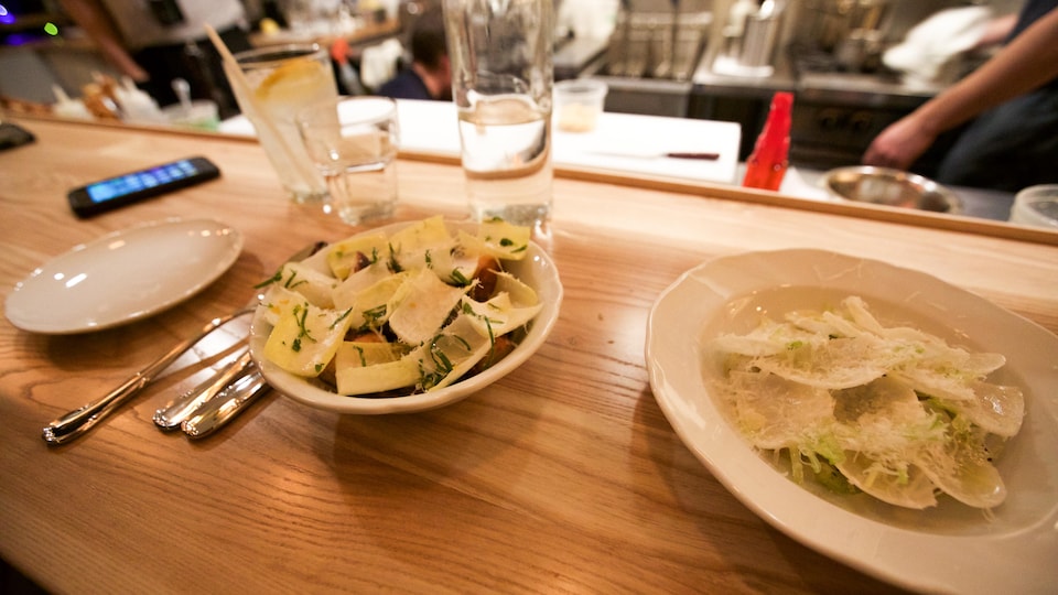 Deux plats sur le comptoir du restaurant Battuto: pieuvre sur un ragoût de lentilles au bouillon au lapin, pétoncles crus et rabioles.
