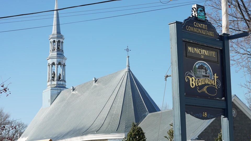 L'affiche de la municipalité de Beaumont devant le clocher de l'église.