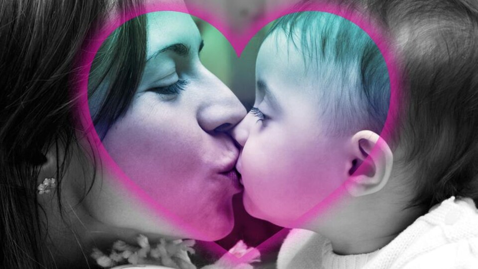 Une mère embrasse son bébé sur la bouche.