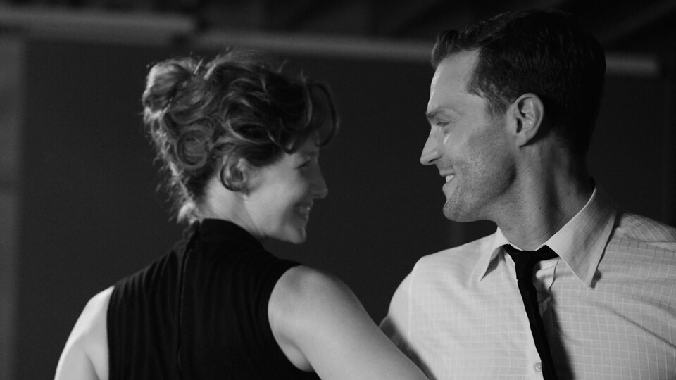 Un couple danse en souriant.
