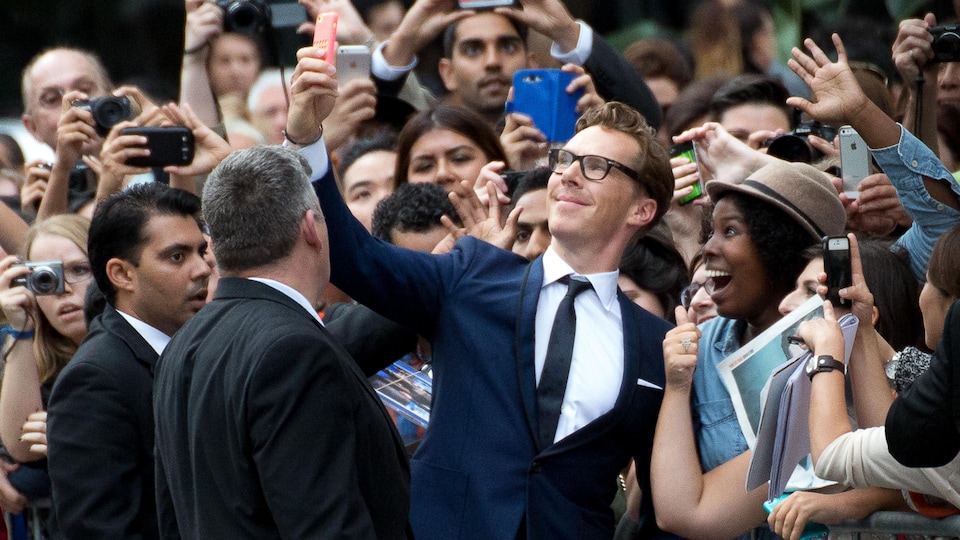 L'acteur britannique Benedict Cumberbatch prend une photo avec une admiratrice sur le tapis rouge.