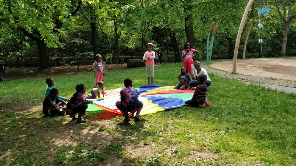 Des enfants sont en train de monter une tente sur une pelouse.