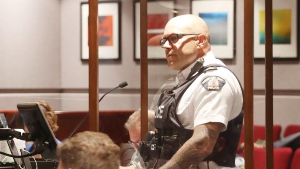 Un policier dans la salle du conseil municipal à Moncton.