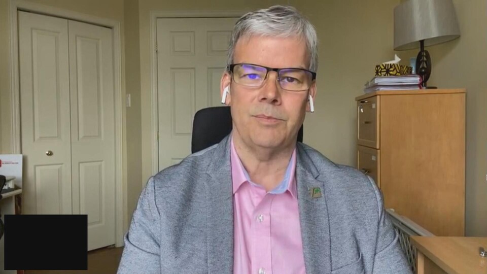 Un homme accorde une entrevue par visioconférence. 