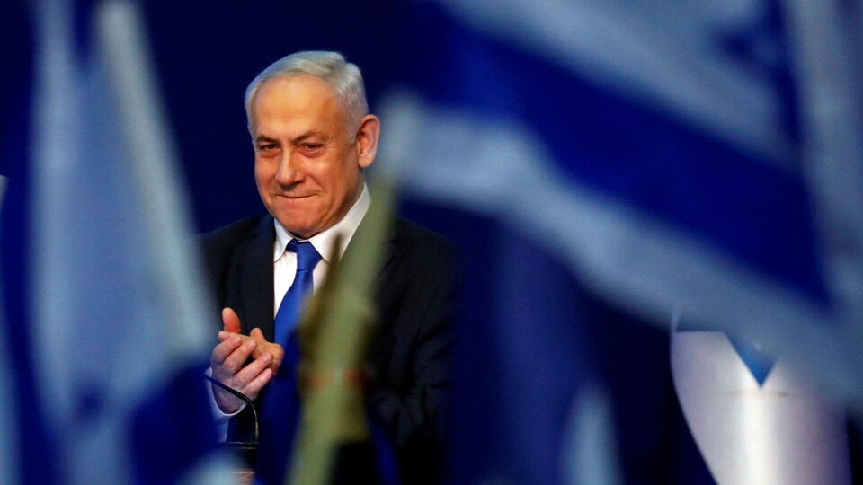 Le premier ministre israélien Benyamin Nétanyahou est entouré de drapeaux bleus et blancs.
