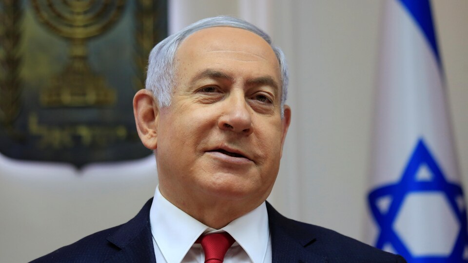 Le premier ministre israélien Benyamin Nétanyahou est photographié devant un drapeau d'Israël.