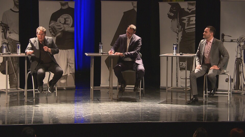 Jean-François Roberge, Bernard Drainville et Mathieu Lacombe sur la scène de l'auditorium de l'Académie les Estacades, à Trois-Rivières.