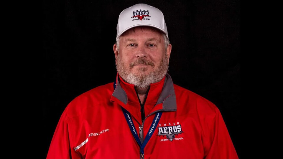Une personne barbue et portant une casquette de l'équipe de hockey junior, AEROS d'Edson, en Alberta.