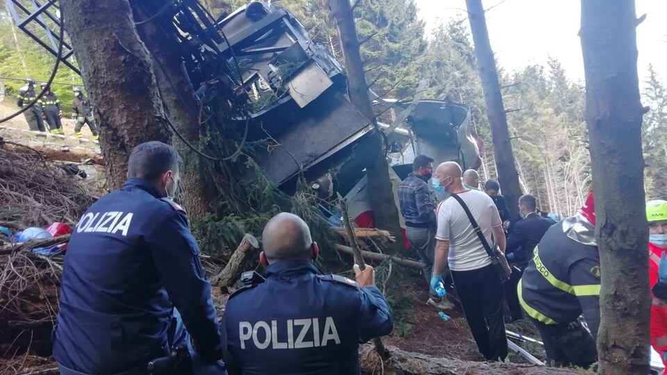 Sur cette photo fournie par la police italienne, des secouristes entourent l'épave du téléphérique tombé de la ligne Stresa-Alpine-Mottarone.
