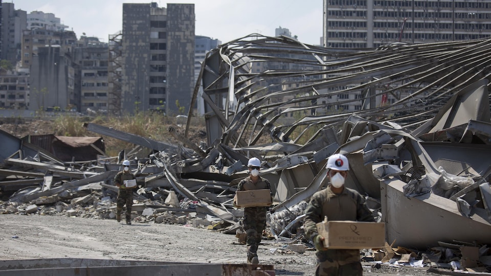 Des soldats transportent des cartons sur le site de l'explosion meurtrière du 4 août dans le port de Beyrouth.