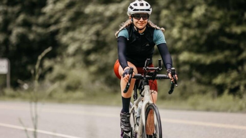 Une femme portant des vêtements sportifs, à vélo.