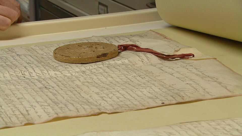 Une lettre manuscrite et un médaillon.