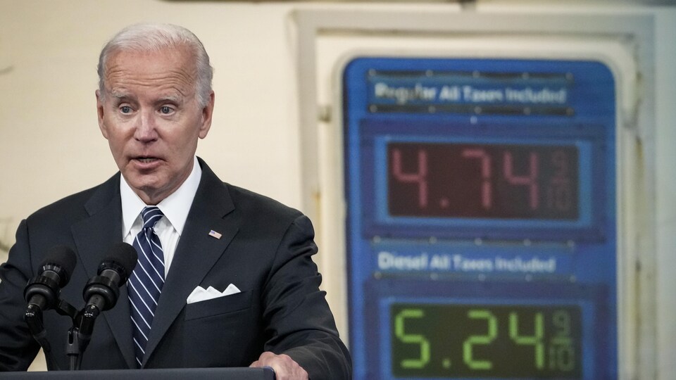 Joe Biden prononce un discours devant un panneau vidéo.