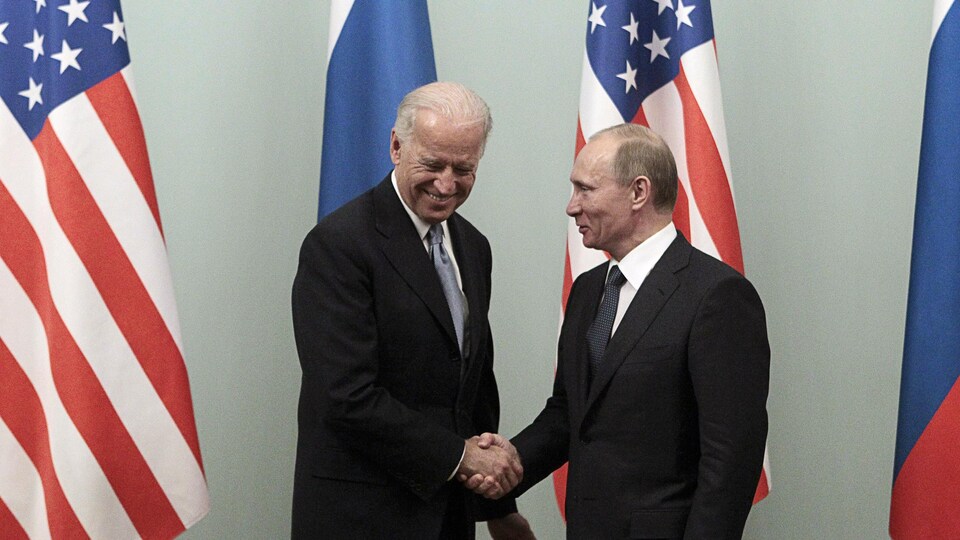 Joe Biden et Vladimir Poutine se serrent la main.