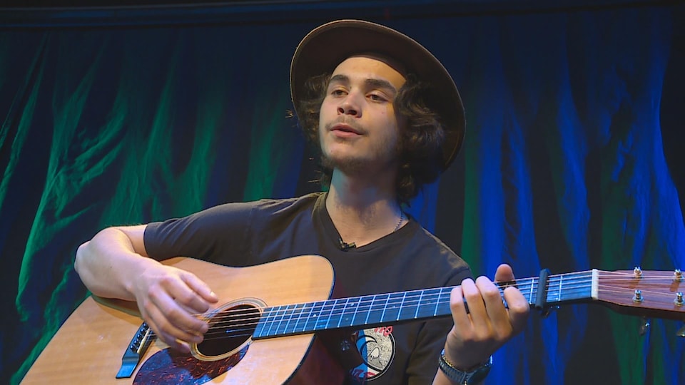 Jacques Surette joue de la guitare.