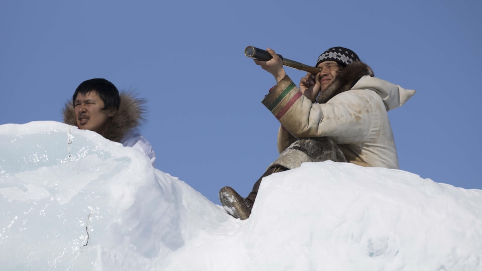 Deux Inuits scrutent l'horizon.