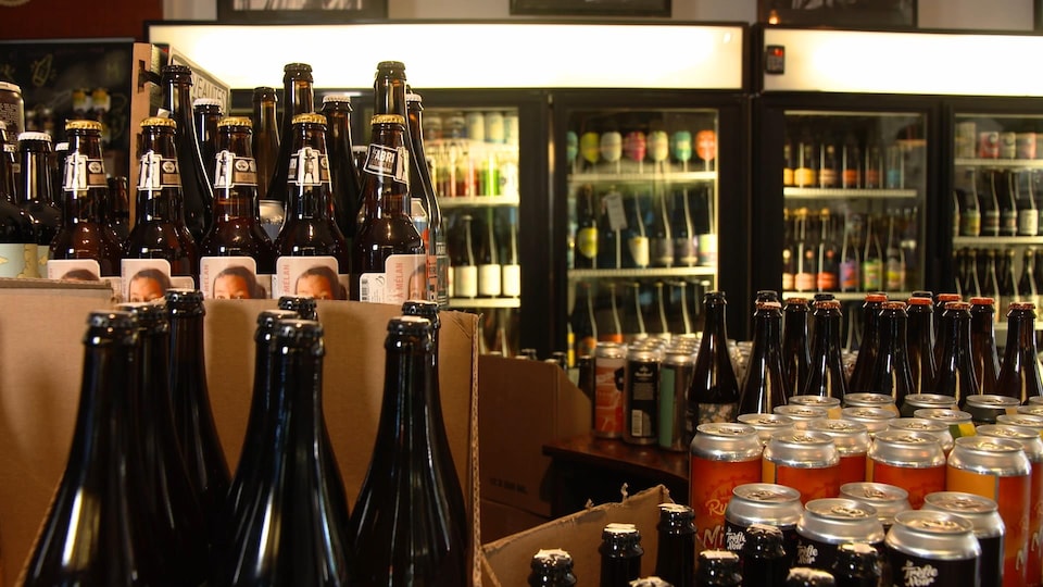 Des bouteilles et des canettes de bière dans un commerce de détail.