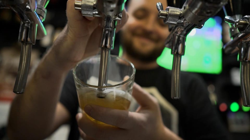 Un employé sert une bière à la pression.