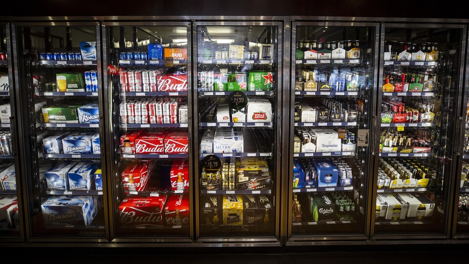 Des réfrigérateurs remplis de bière dans un commerce.