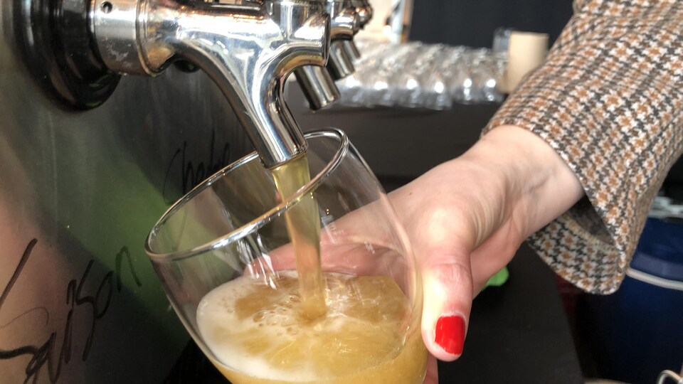 Une étudiante verse de la bière dans un verre.
