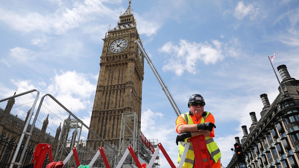 Un travailleur de la construction se repose devant la célèbre Tour Elizabeth, mieux connue sous le nom de Big Ben, à Londres.