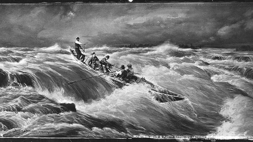 Des hommes descendent les rapides en canot