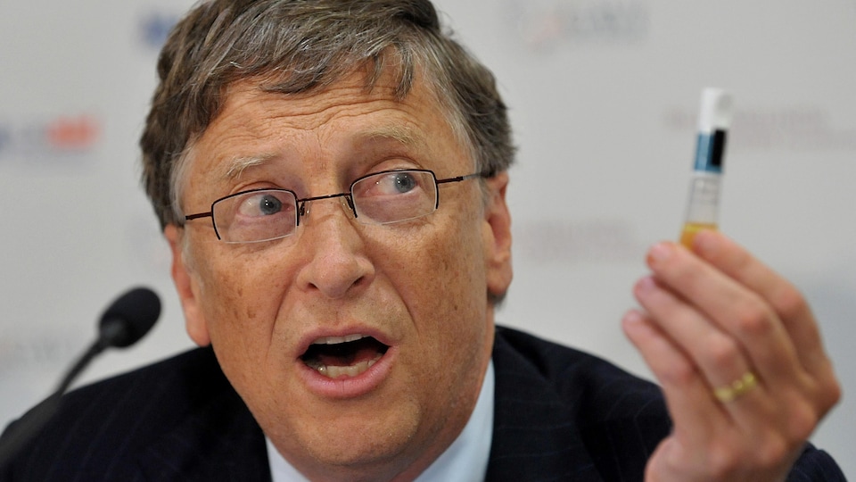 Bill Gates tient un flacon de vaccin lors d'une conférence de presse.