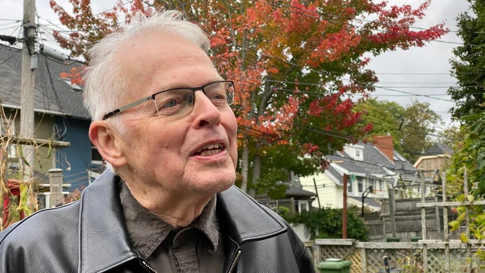 Bill VanGorder parle dehors sous un arbre, à l'automne.