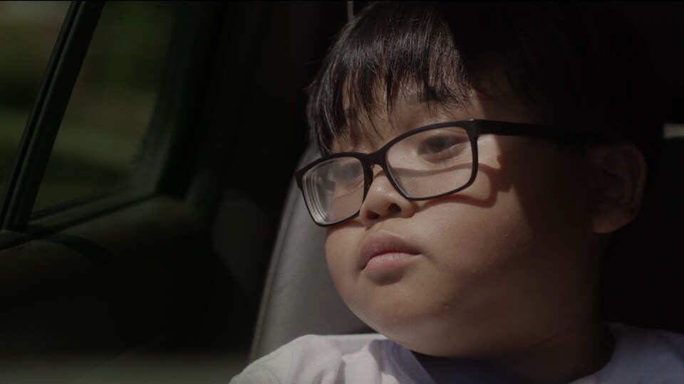Le personnage de Bing est assis dans une voiture. Il porte des lunettes.