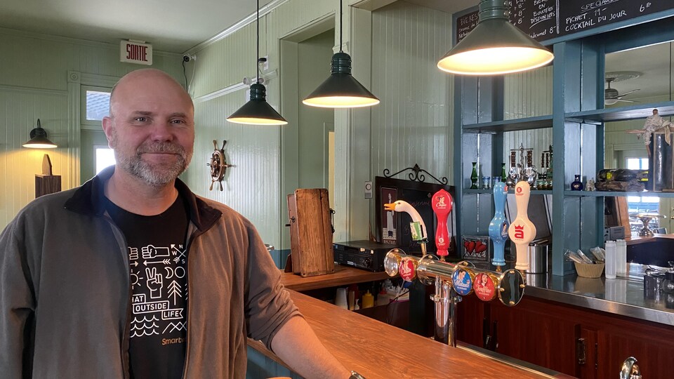 Un homme devant un bar de restaurant.