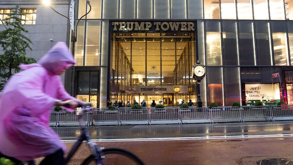 Un cycliste circule sur la 5th Avenue devant la Trump Tower, près de laquelle on voit des clôtures de protection.