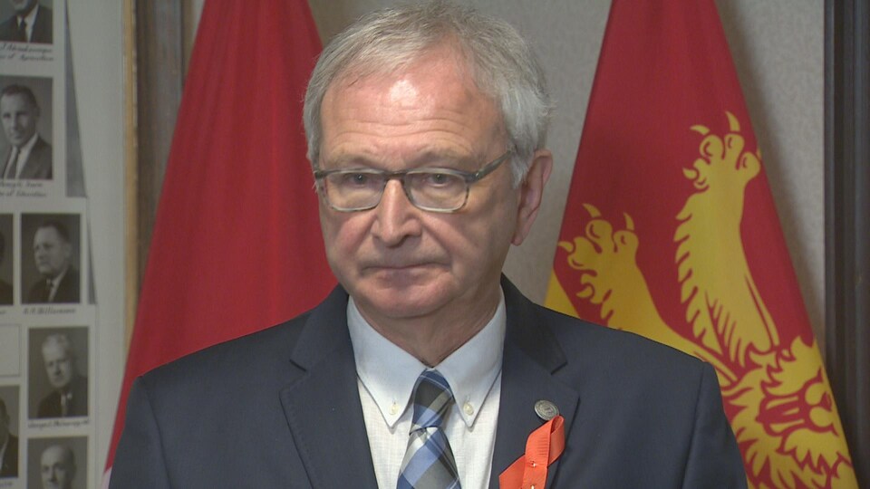 Le premier ministre du Nouveau-Brunswick, Blaine Higgs, devant des drapeaux, le 9 juin 2021.