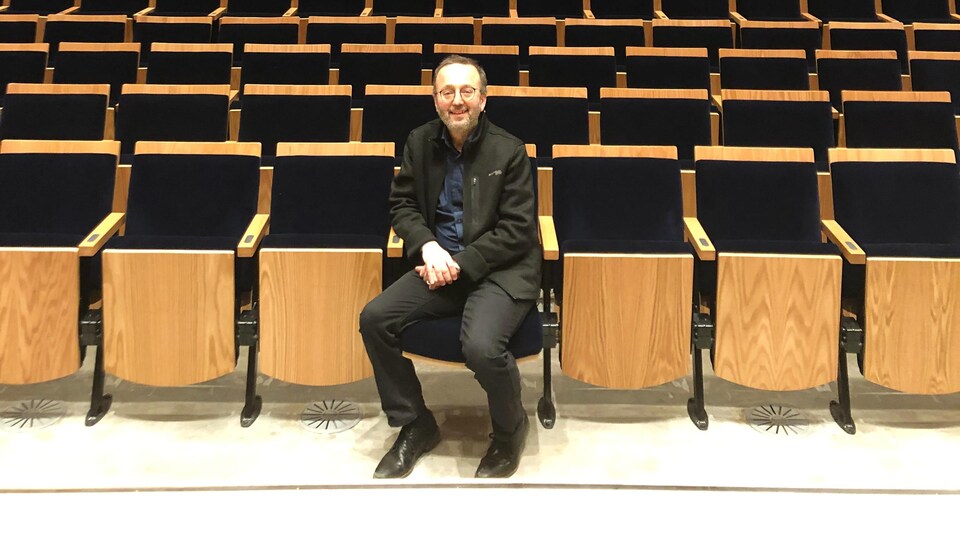 Jérôme Blais assis au premier rang de la nouvelle salle de concert.