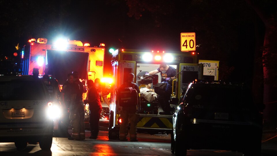 Des ambulanciers prennent en charge un homme blessé par balle.