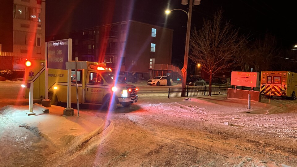Une ambulance entre dans le stationnement enneigé de l'hôpital de Rimouski la nuit.