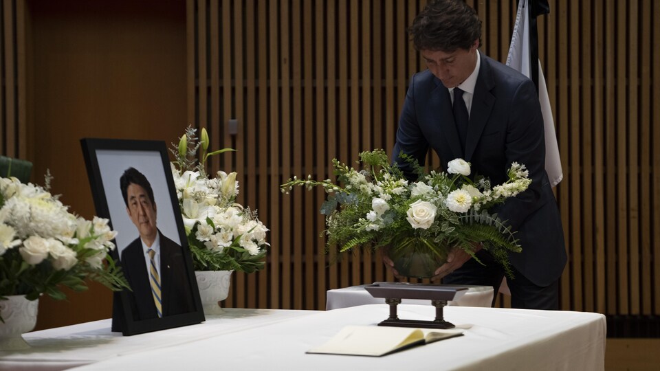 Le premier ministre canadien Justin Trudeau dépose des fleurs sur une table avant de signer un livre de condoléances pour l'ancien premier ministre japonais Shinzo Abe.
