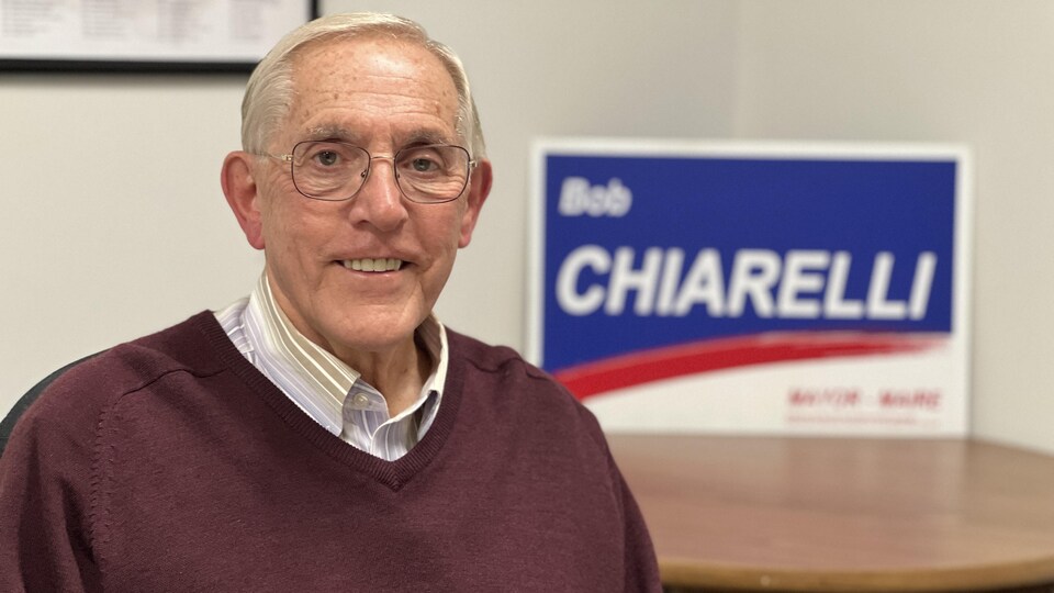 Bob Chiarelli pose devant l'une de ses pancartes électorales dans son bureau. 