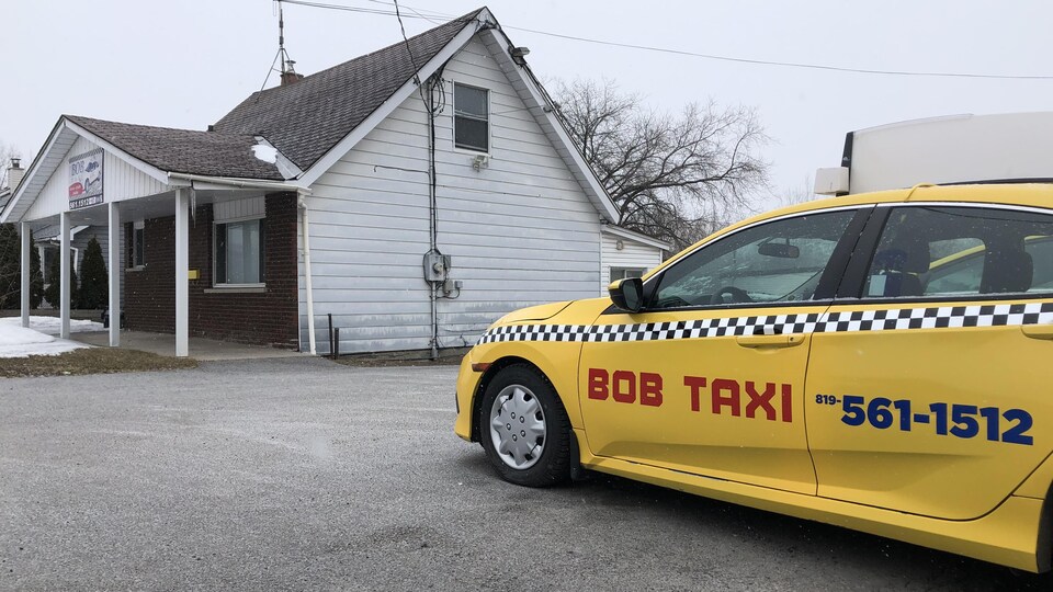 Une voiture de taxi dans un stationnement, en hiver.