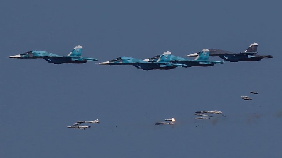 Des avions Sukhoi Su-34 russes larguent des bombes lors de manoeuvres aériennes.