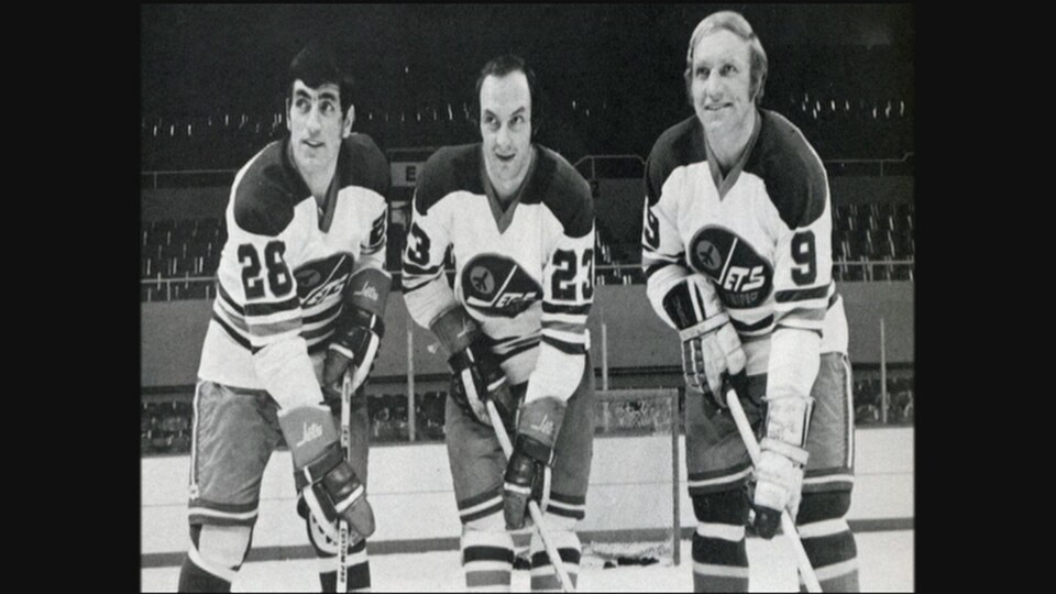 Bobby Hull dans une photo d'archives en noir et blanc avec deux autres coéquipiers. 
