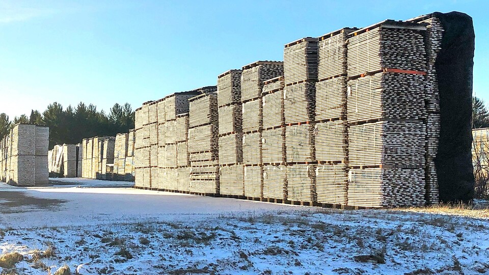 Des palettes de bois empilées à l'extérieur de Planchers Lauzon.