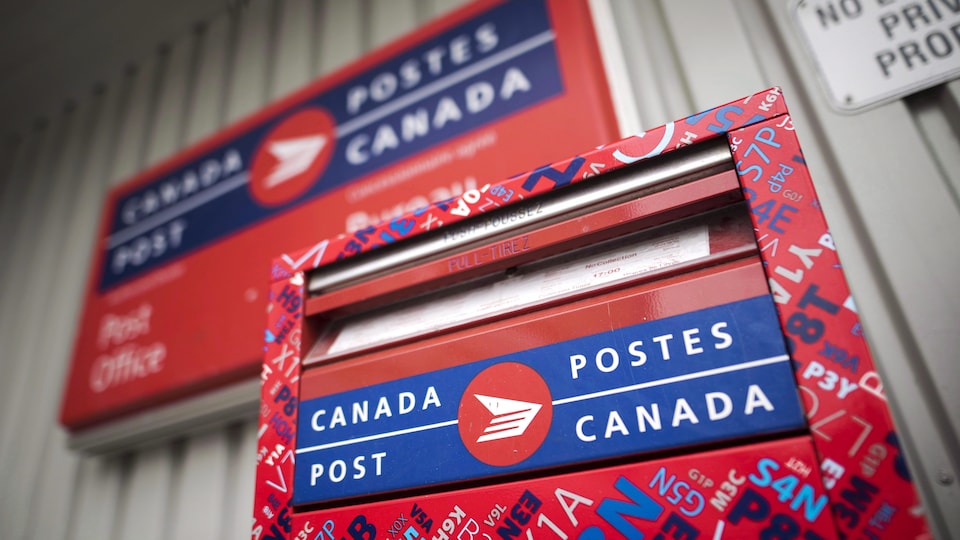 Une boîte aux lettres devant un bureau de Postes Canada.
