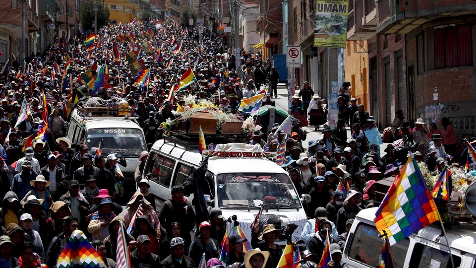 Une foule dans la rue avec des drapeaux autochtones.